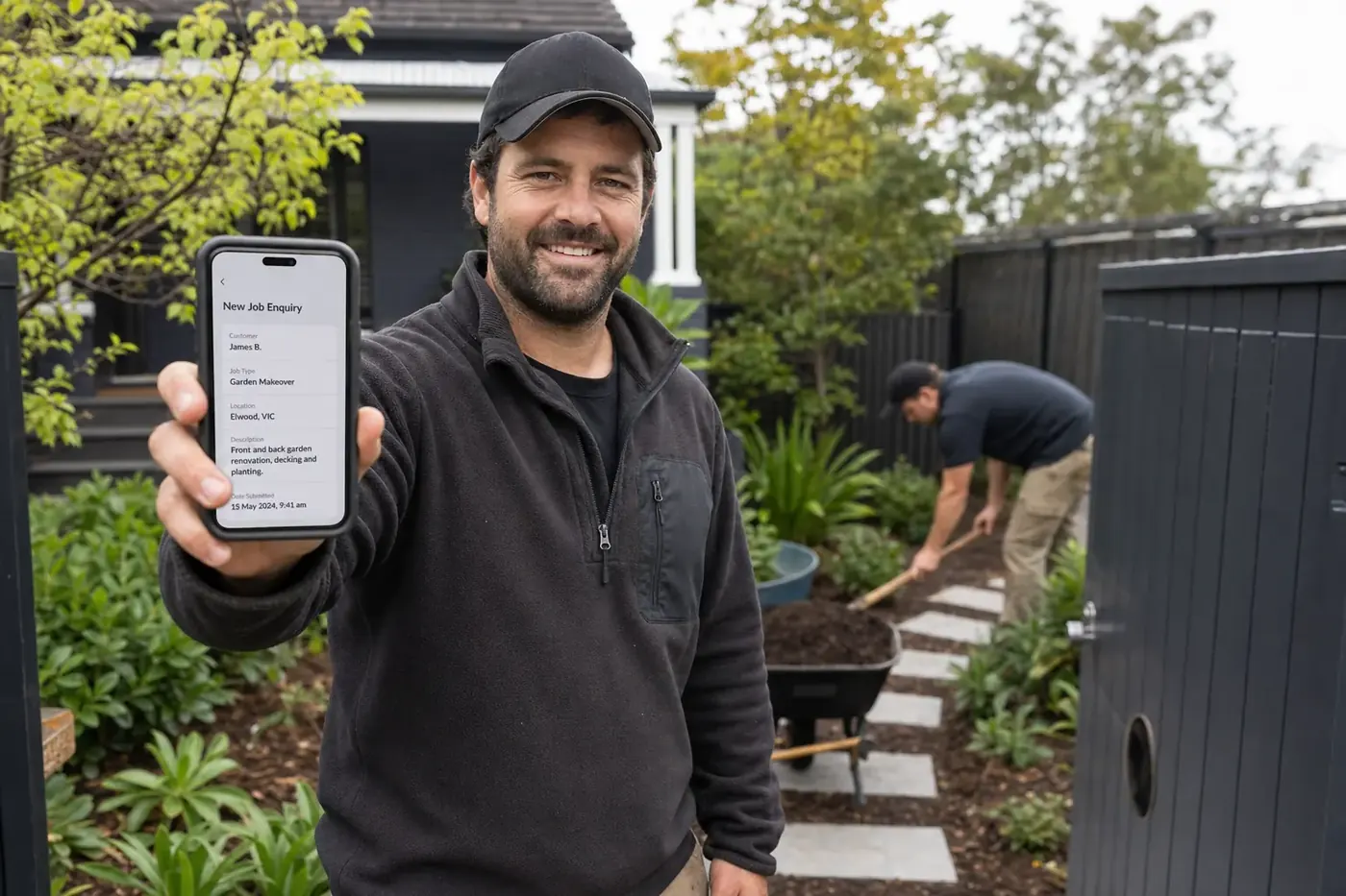 Melbourne landscaper taking a new enquiry on the phone in a customer's front garden